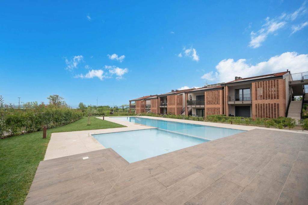 an image of a swimming pool in front of a building at ApartmentsGarda - Cuore del Garda in Ronchi