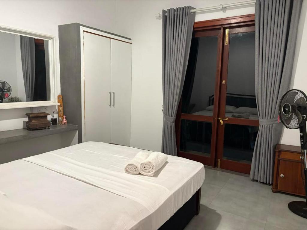 a bedroom with a bed with two towels on it at Taku Home Stay in Kandy
