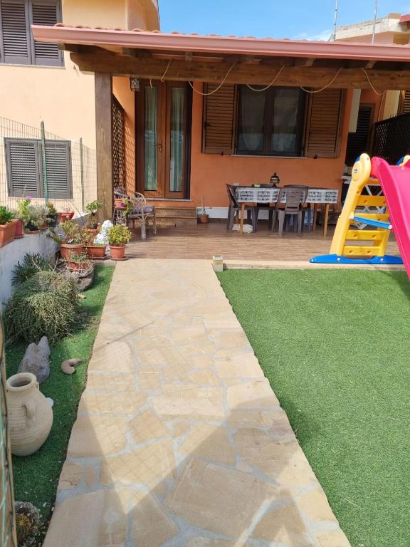 un patio trasero con parque infantil y tobogán en Casa Alessia, en SantʼAnna Arresi