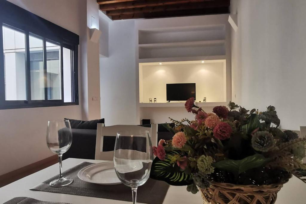 einen Tisch mit zwei Weingläsern und einer Vase Blumen in der Unterkunft Apartamento Bella Sultana, Centro Histórico in Córdoba