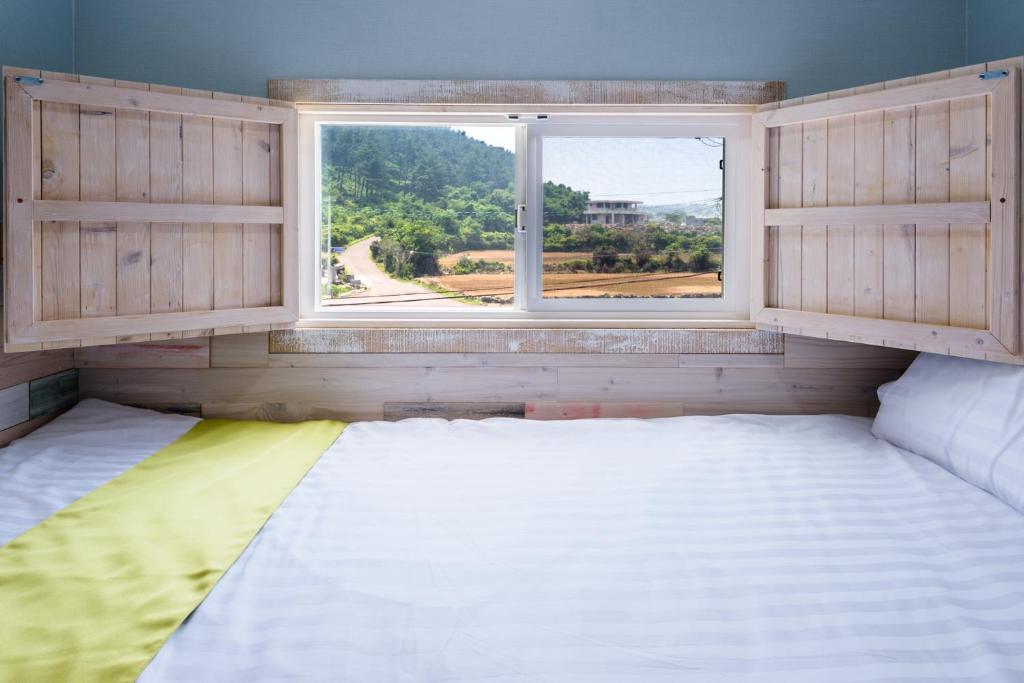 a room with two beds and a window at White star in Jeju