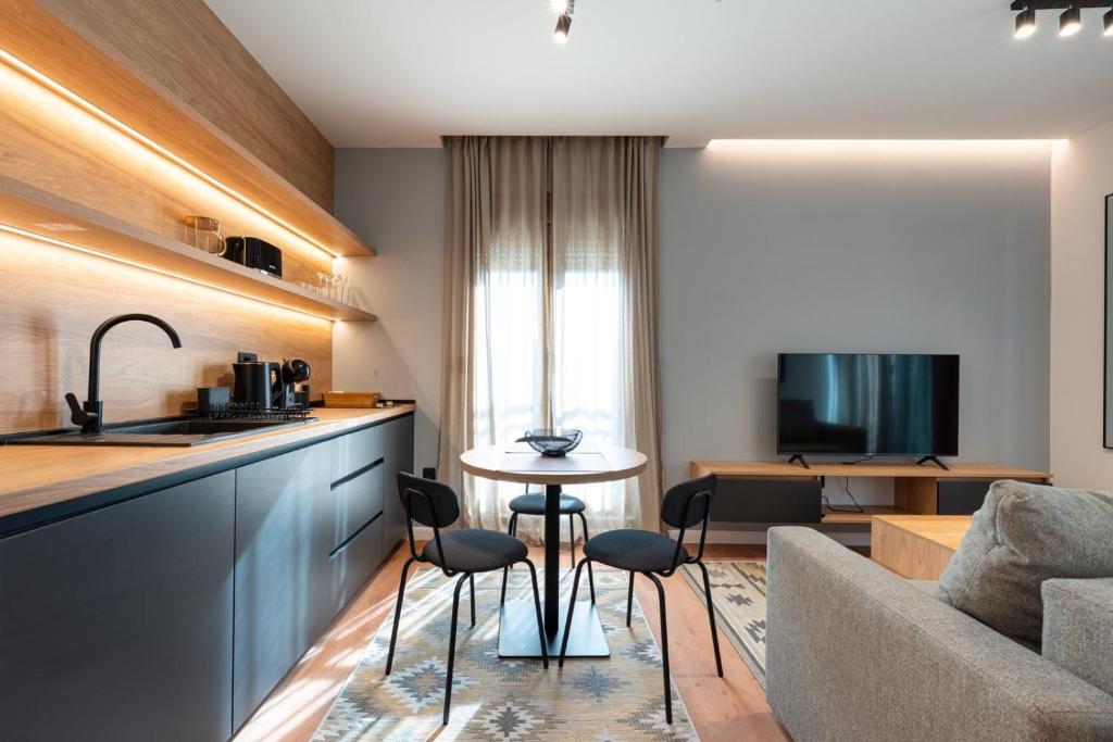 a kitchen and living room with a table and a couch at Nanooq Apartments in Kolašin