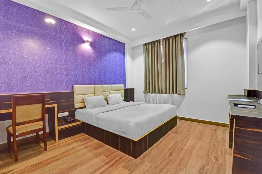 ジャイプールにあるHotel Karma Inn I Hotel Near To Jaipur Airportの紫の壁のベッドルーム1室(ベッド1台付)