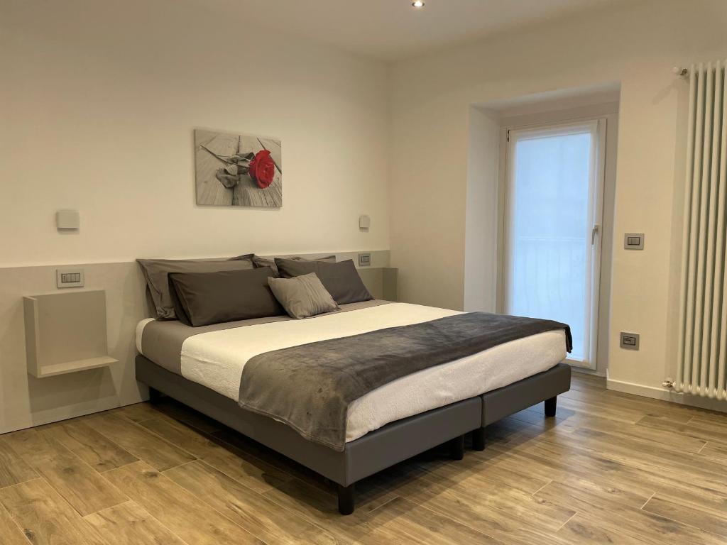 a bedroom with a large bed with a red rose on the wall at Cà Marasciol in Villa di Tirano
