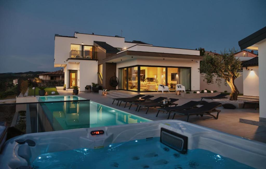 a house with a swimming pool in front of a house at Gorgeous Home In Momjan With Sauna in Momjan