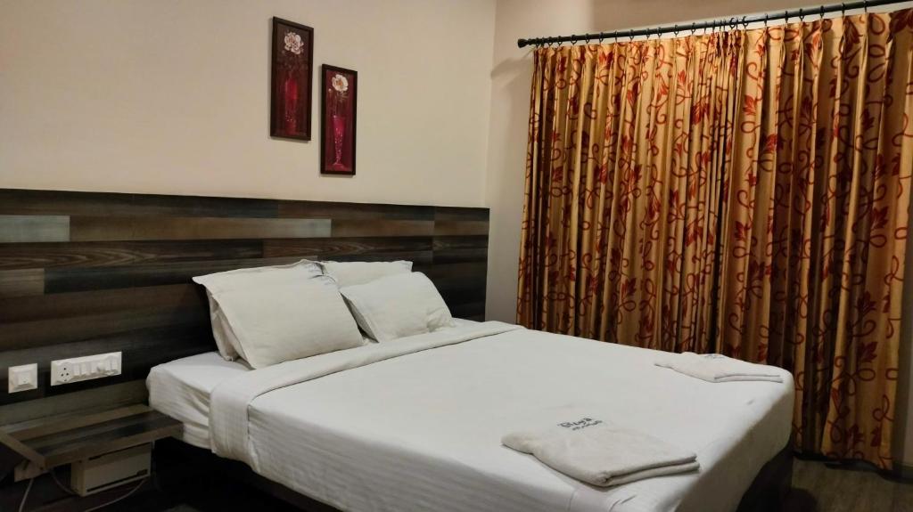 a bedroom with a large bed and a curtain at Royal Service apartment - KK Nagar Madurai in Madurai