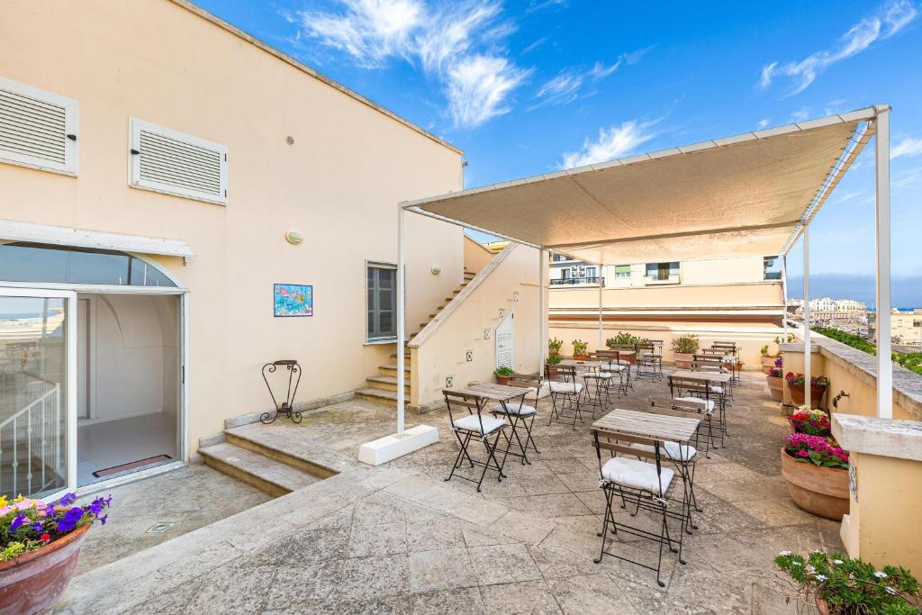 ガリポリにあるB&B Palazzo Vergineの建物の前のテーブルと椅子のあるパティオ