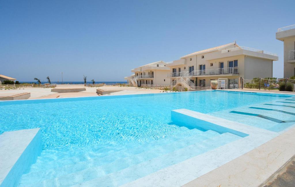 a large swimming pool in front of a building at 2 Bedroom Beautiful Apartment In Marzamemi in Marzamemi