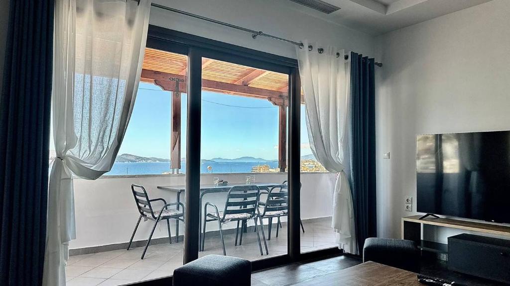 a living room with a balcony with a table and chairs at Thea Penthouse with private parking in Sarandë