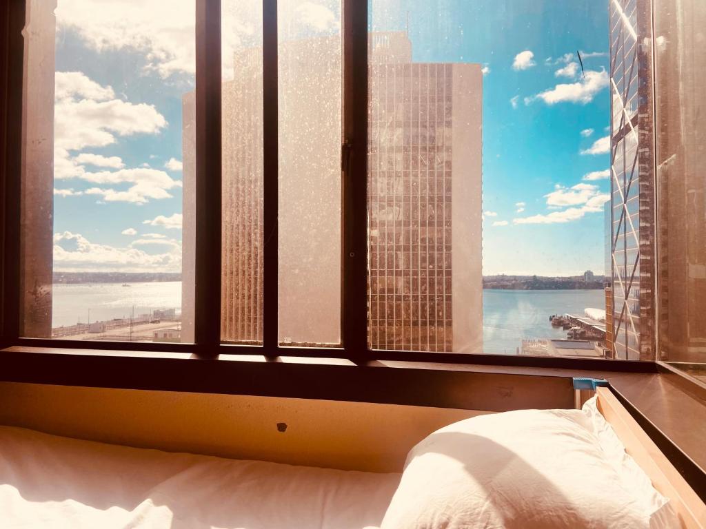 a bedroom with a large window with a view of the city at Garden Hostel in Auckland
