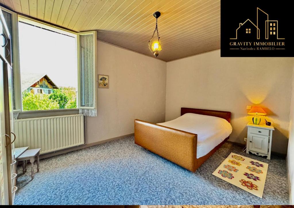 a bedroom with a bed and a window at Le Montagnard in Marignier