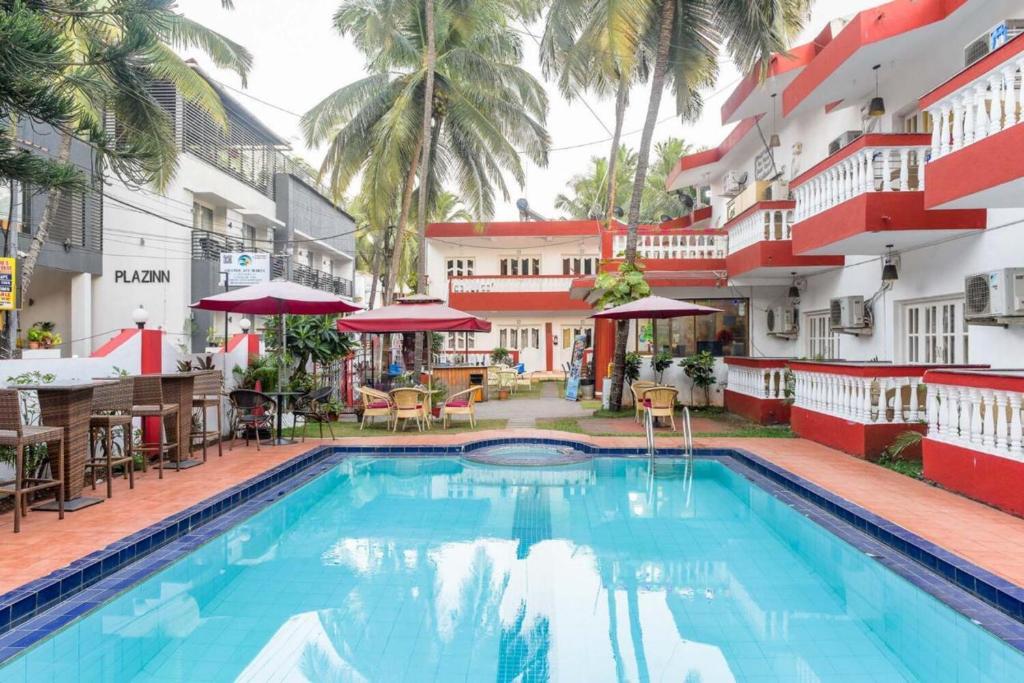 une piscine en face d'un bâtiment avec un hôtel dans l'établissement Grande Ave Maria Resort, à Candolim