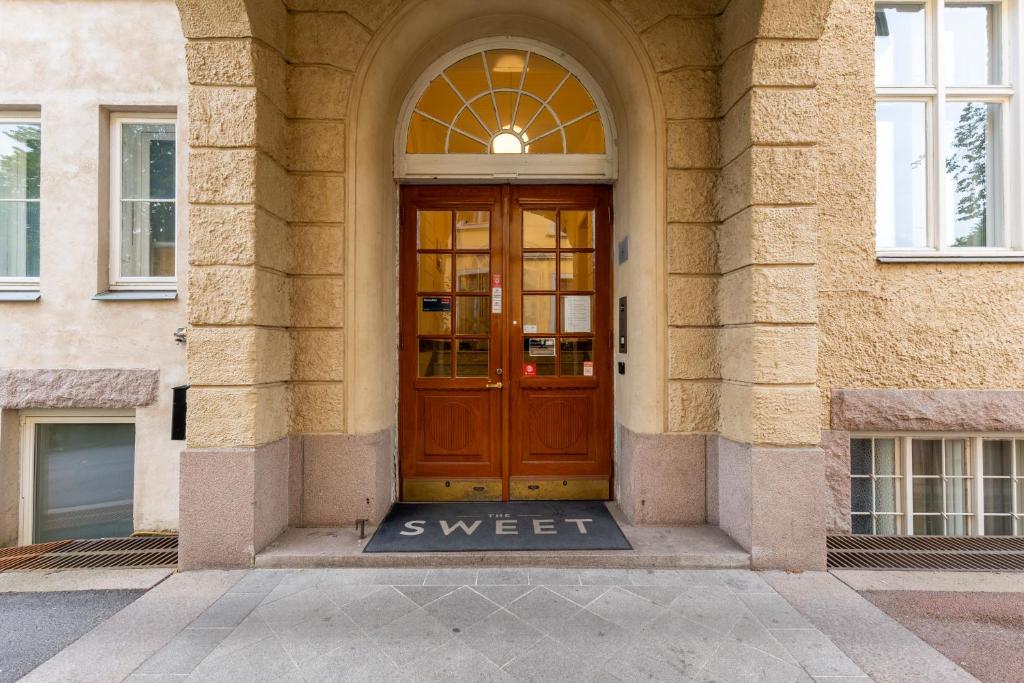 a brown door with the word sweet in front of a building at The Apartments Company - The Sweet in Oslo