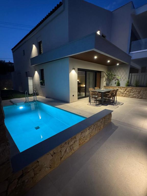 a swimming pool in front of a house at night at Villa El Mar in Gerakini