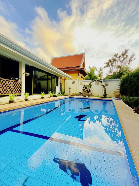 a swimming pool in front of a house at Sanuk bungalows in Rawai Beach