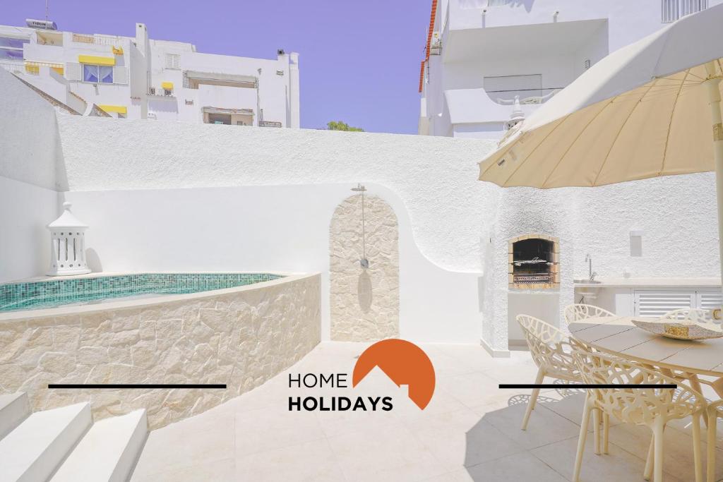 a view of a house with a patio with a table and chairs at #128 Number 10 Villa by Home Holidays in Albufeira