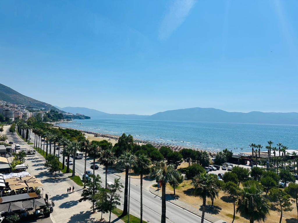 una vista di una spiaggia con palme e l'oceano di Blue Escape Apartment Lungo Mare a Vlorë