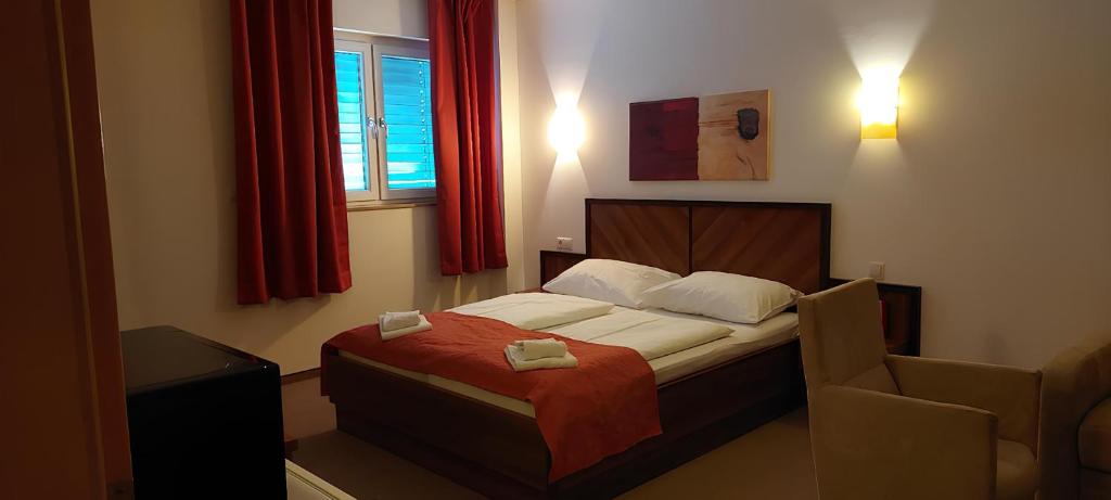 a bedroom with a bed and a window with red curtains at Weinland in Donnerskirchen