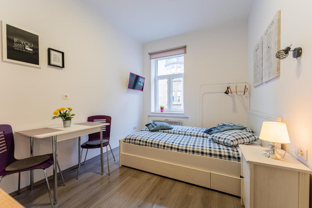 a bedroom with a bed and a table and chairs at Flex SelfCheckIns 130 - Zagreb - Studio Apartment - Center in Zagreb