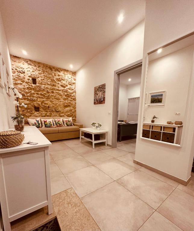 a large living room with a couch and a stone wall at Tannur Del Carmine in Noto