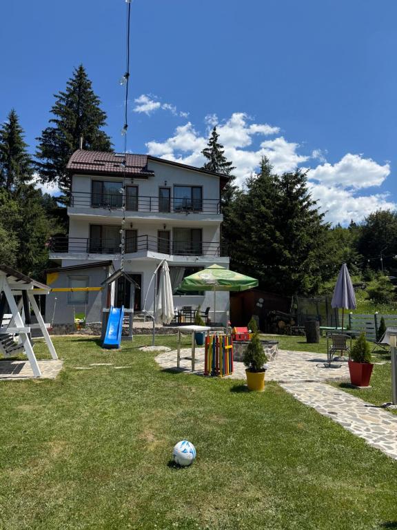 a house with a soccer ball in the yard at Pensiunea Crescent Predeal in Predeal