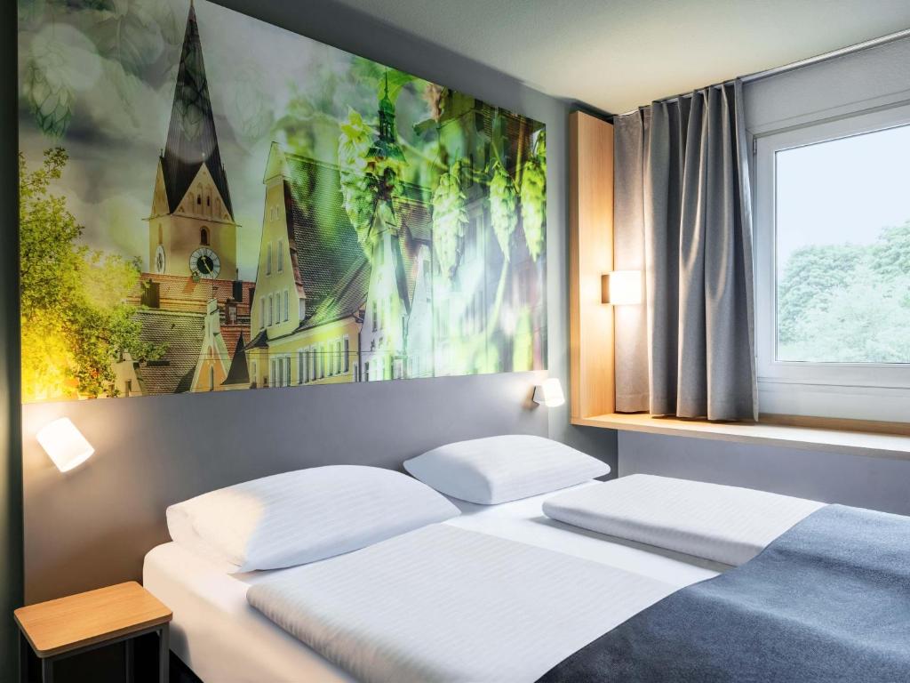 Un dormitorio con dos camas y un cuadro en la pared. en B&amp;B Hotel Ingolstadt-Ost, en Ingolstadt