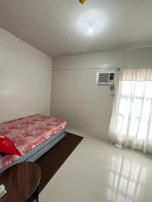 a small room with a bed and a window at RCL Homestay condo unit in Mactan Island