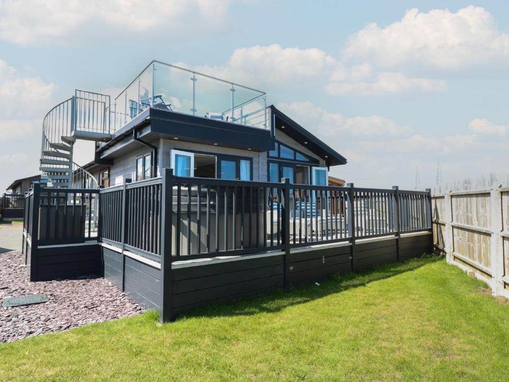 a house with a balcony on a fence at Life's a Beach in Norwich