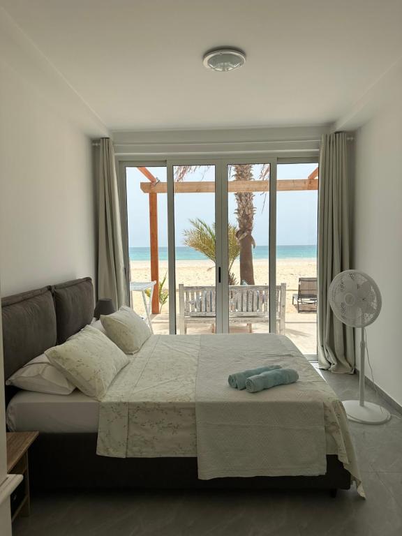 萨尔雷Villa Cristina Alojamento, Praia de Chaves, Boa Vista, Cape Verde, WI-FI的一间带床的卧室，可欣赏海滩景色