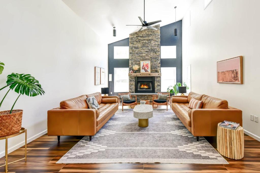 a living room with leather couches and a fireplace at Luxury Mountain Retreat - 4 King Suites & Hot Tub in Harpers Ferry