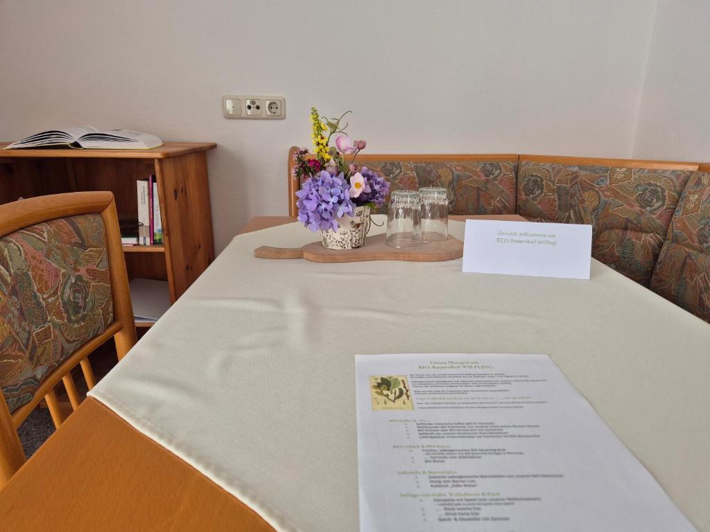 a table with a white table cloth and flowers on it at Bio-Bauernhof Wilfling in Miesenbach