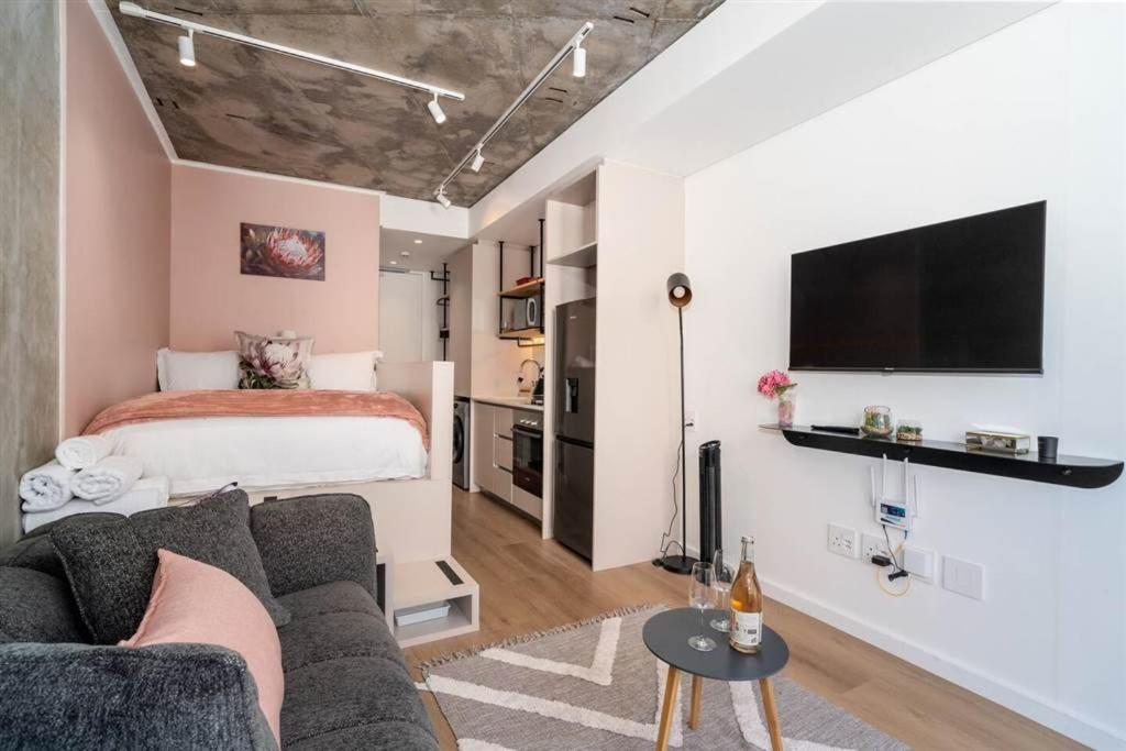una sala de estar con un sofá y una cama en Apartment in Seapoint, en Ciudad del Cabo