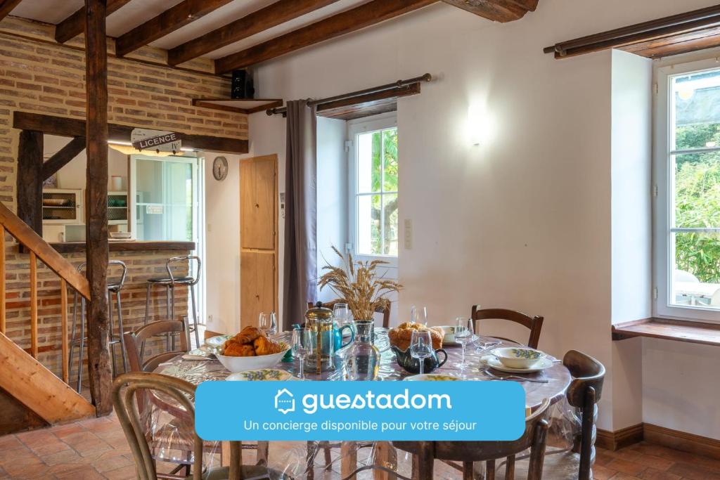 a dining room with a table and chairs at Le Chêne des Loges - Campagne - Familial in Bouère