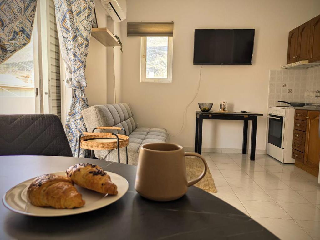 ルートラキにあるA cozy apartment by the seaのリビングルームのテーブルの上にクロワッサン2個が載った皿