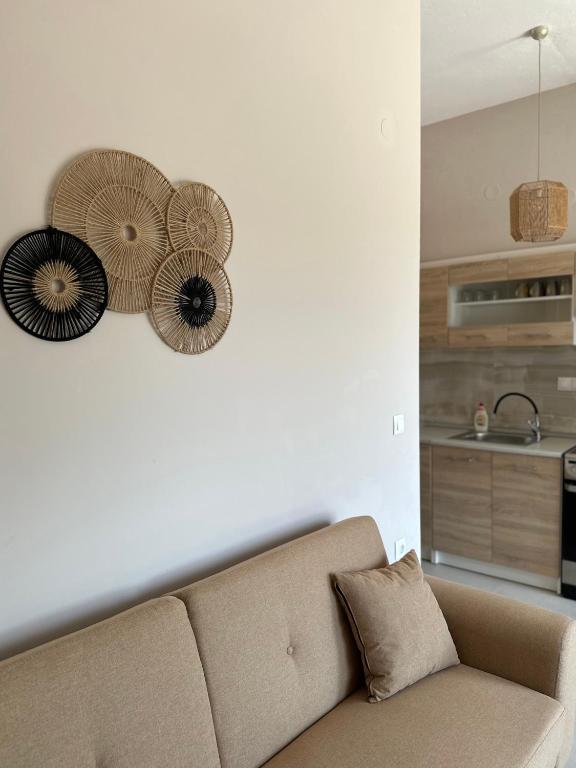 a living room with a couch and some fans on the wall at Golden Beach Apartments in Chrysi Ammoudia