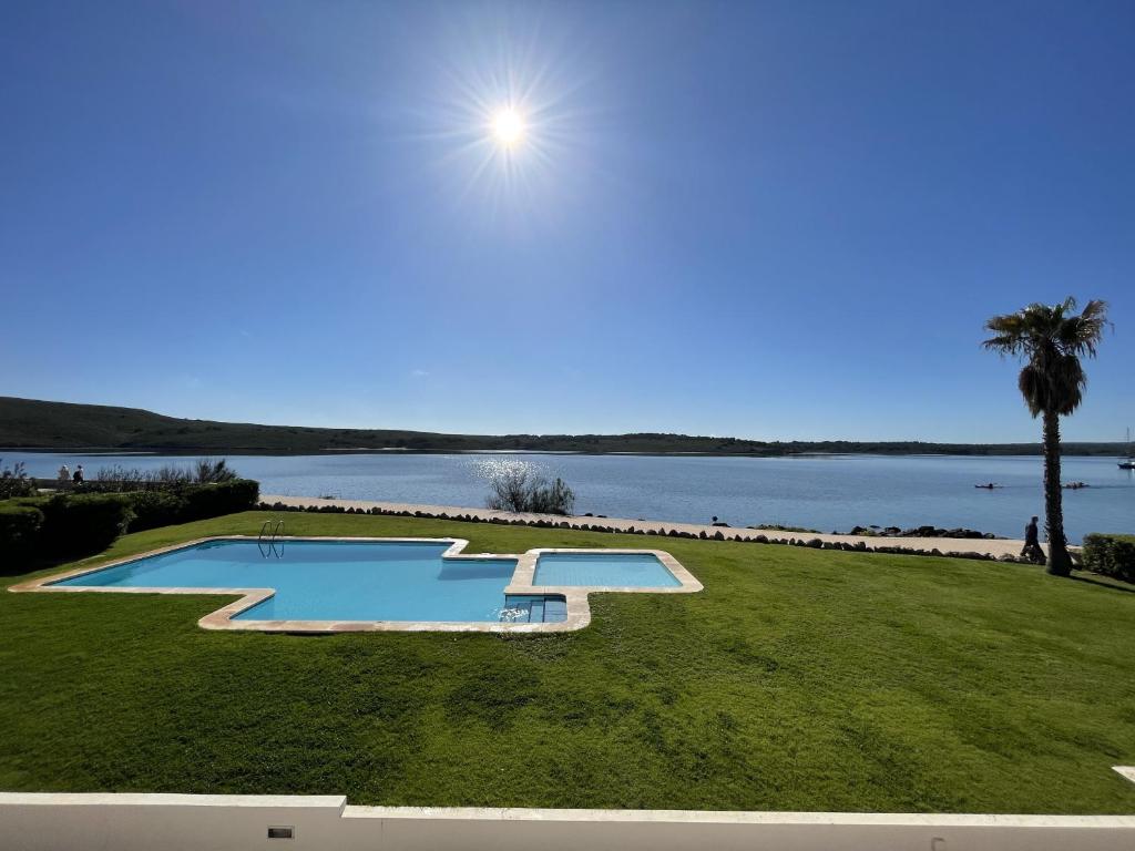 a swimming pool with a view of a body of water at ES CASTELL 1 1 by SOM Menorca in Fornells