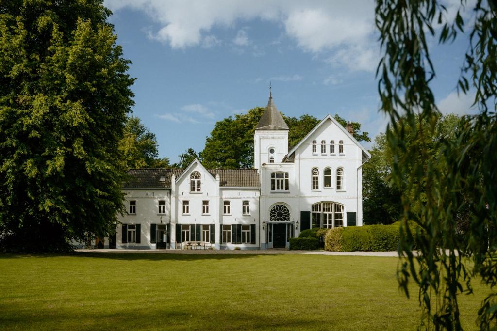 ein großes weißes Haus mit einem großen Garten in der Unterkunft Landgoed Frymerson in Sint Odiliënberg