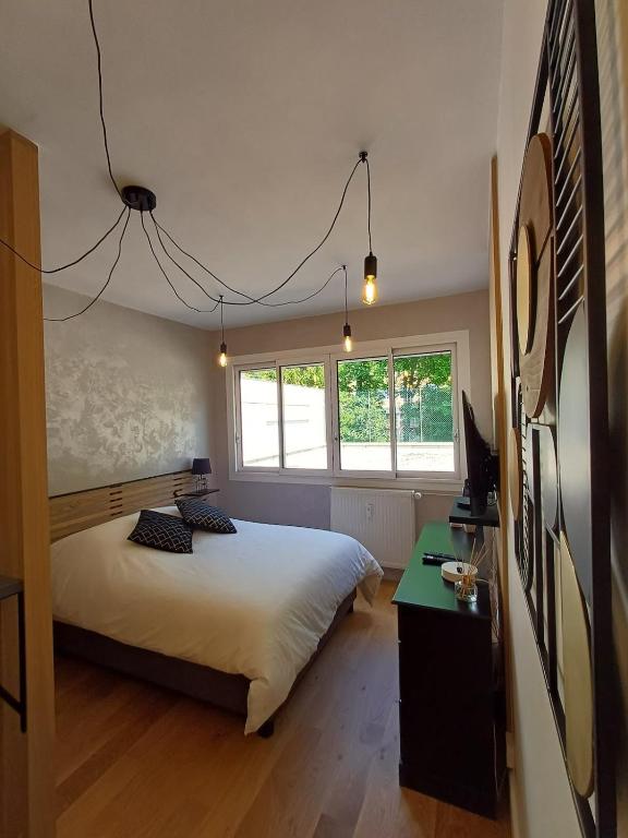 une chambre avec un lit, un bureau et des fenêtres dans l'établissement The Brut Case - Avenue de Champagne, à Épernay