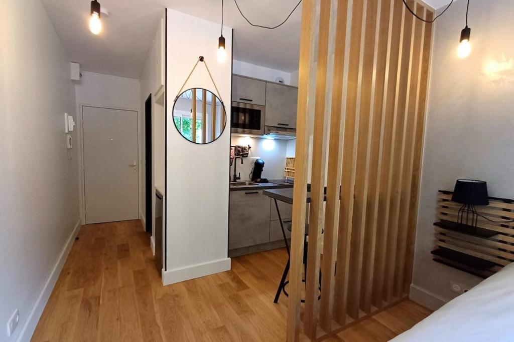 a room with a bed and a kitchen with a mirror at The Brut Case - Avenue de Champagne in Épernay
