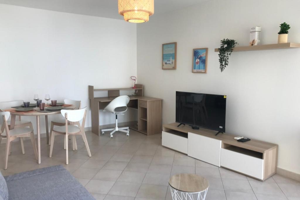 a living room with a flat screen tv and a table at Les Clés d'Or d'Antibes in Antibes