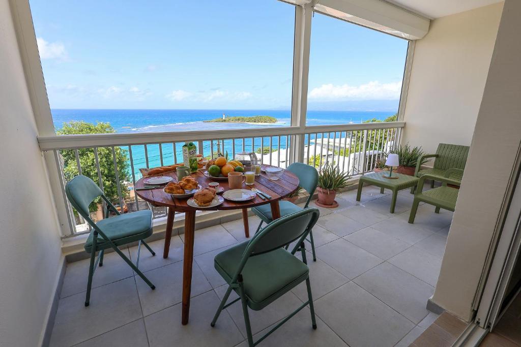 a dining room with a table and chairs and the ocean at La Terrasse du Gosier in Le Gosier