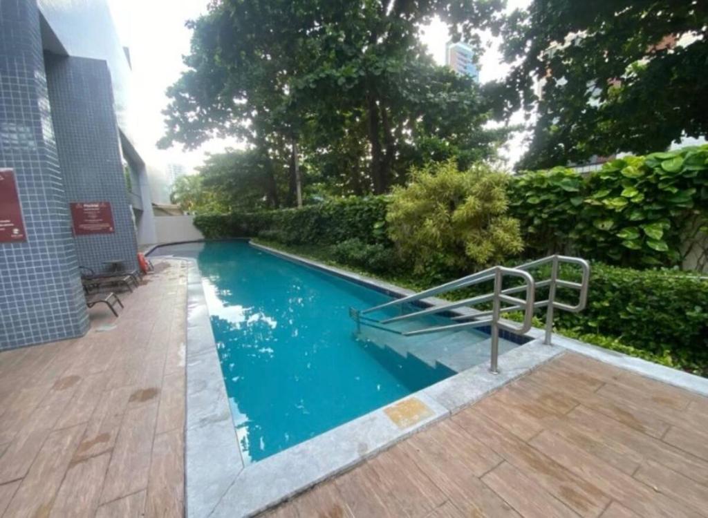 una piscina con una escalera en un patio en Excelente Flat Boa Viagem Andar Alto, en Recife
