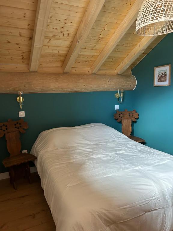 un letto in una stanza con soffitto in legno di T3 classé 3 étoiles, pour 6 personnes dans un Chalet a Saint-Michel-de-Maurienne