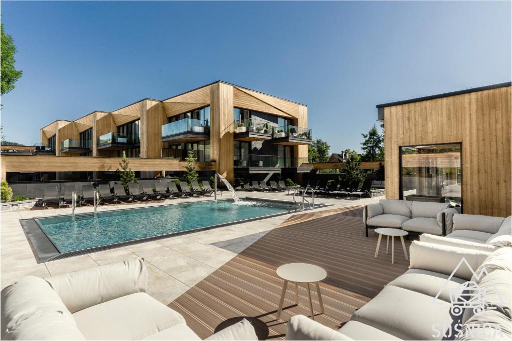 a house with a swimming pool and a building at Sośnica Resort & SPA in Zakopane