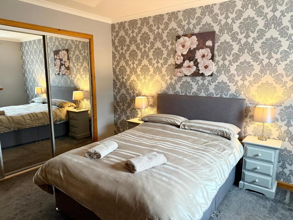 a bedroom with a large bed and a mirror at The Old Salt House, Flat 2 in Wick