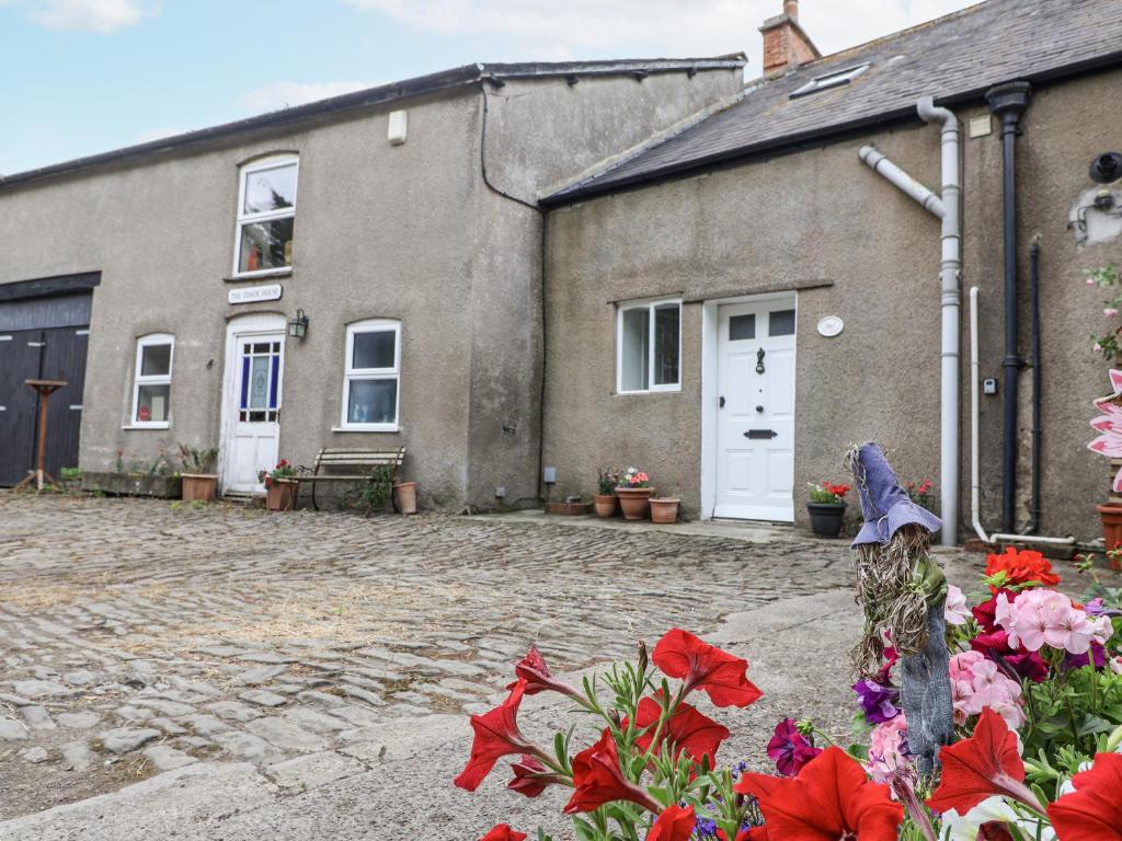 a house with red flowers in front of it at The Cottage in Clevedon