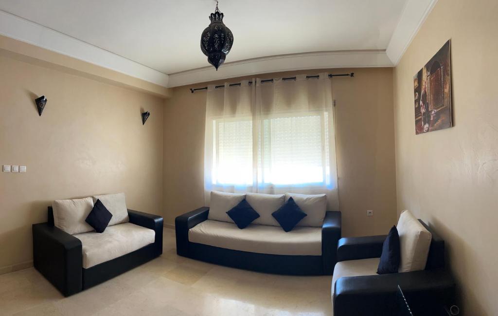 ein Wohnzimmer mit zwei Stühlen und einem Fenster in der Unterkunft Résidence ASSAFA 3 AGADIR Familiale in Agadir