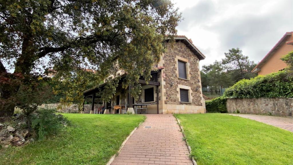 una casa in pietra con un sentiero in mattoni davanti di Casa Rural La Carrasquilla a Golmayo