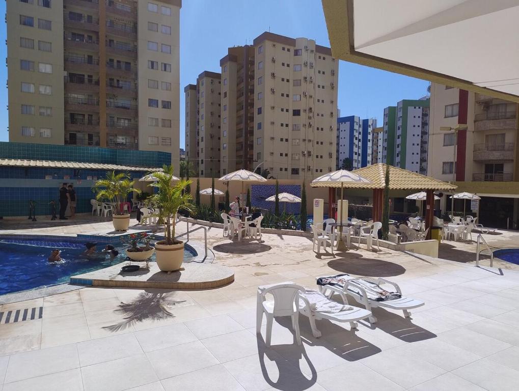 a patio with chairs and a pool and buildings at Spectacular apartment 202C - 7 thermal pools in Caldas Novas
