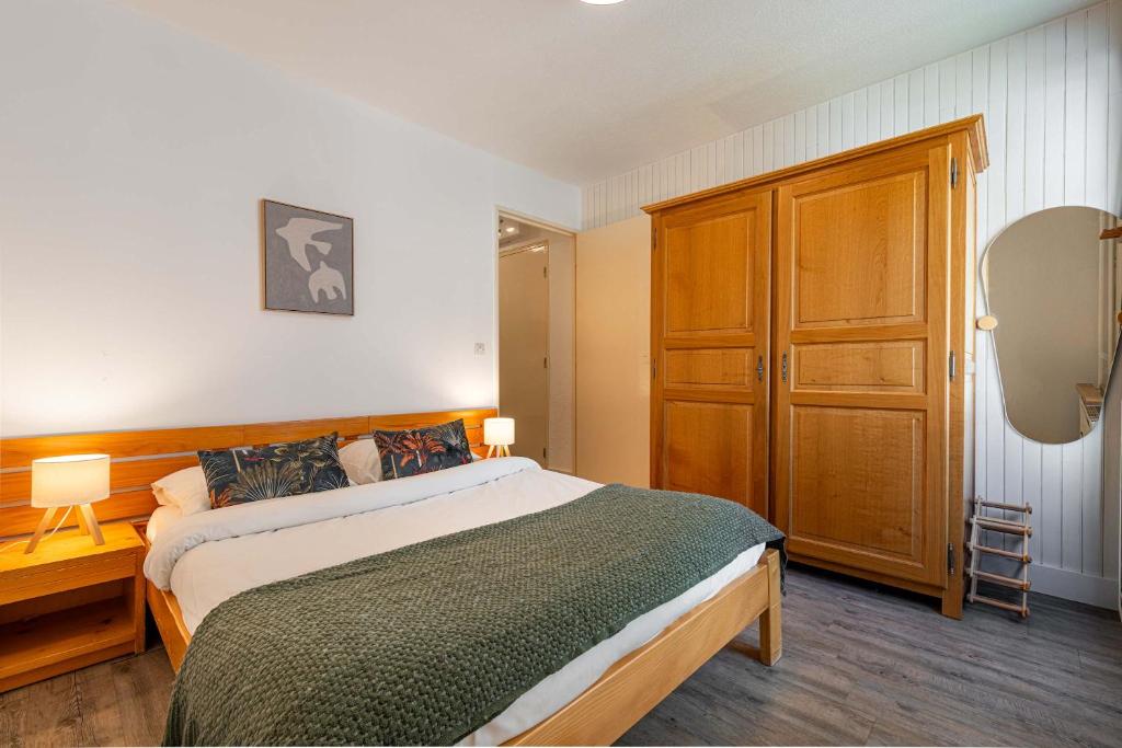 a bedroom with a large bed and a wooden cabinet at Residence Hauts de Chaviere In Val Thorens, Ski In-Out with WiFi in Val Thorens